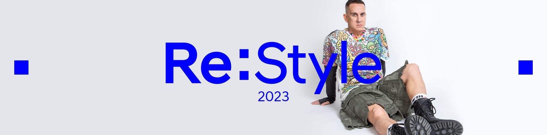 A banner image with Re:Style 2023 written in bright blue. Behind the writing is Jeremy Scott sitting on the right side wearing chunky lace-up black boots, gray cargo shorts and a colorful t-shirt covered in cartoon images.