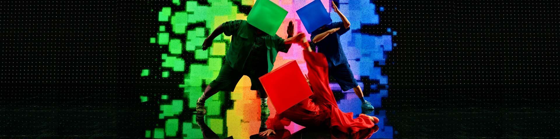 A still of the intro sequence in the "Pixel by Pixel" film depicting a green pixel dancer and red pixel dancer, each with an LED-cube on their head, against a black background.