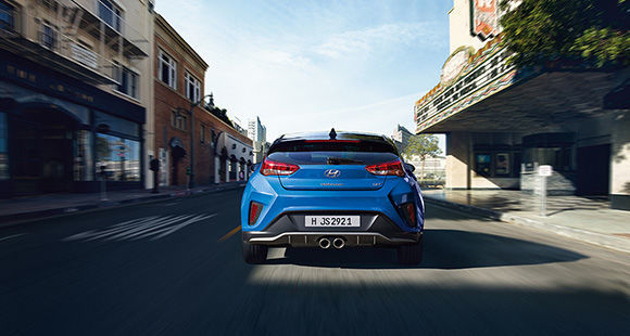 Rear view of blue veloster driving on the road