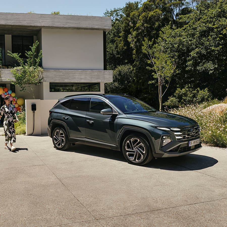 Hyundai TUCSON Plug-in garé devant une maison moderne