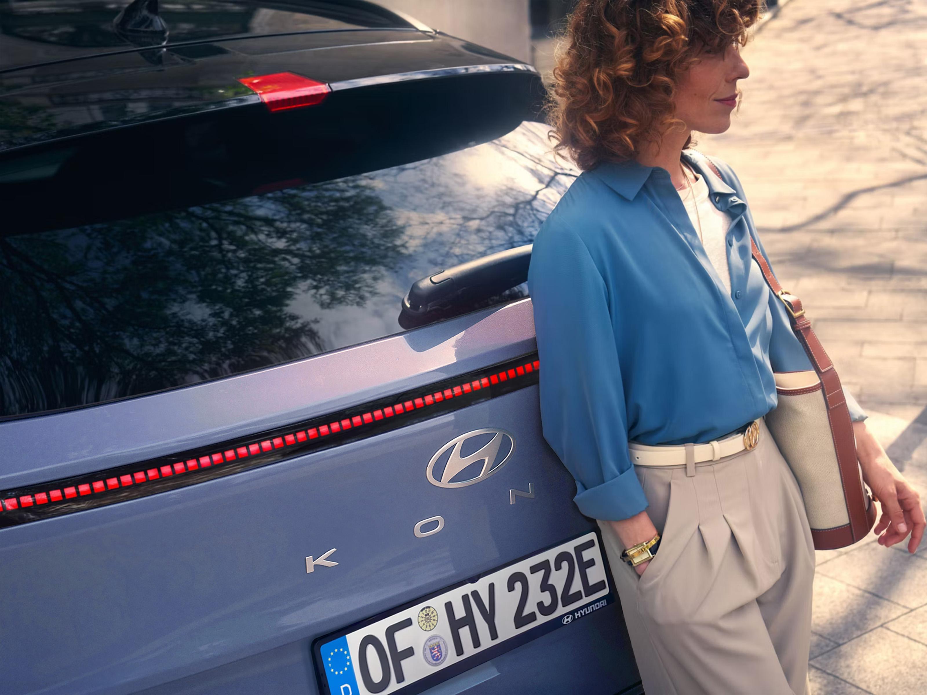 Mujer apoyada en un Hyundai KONA
