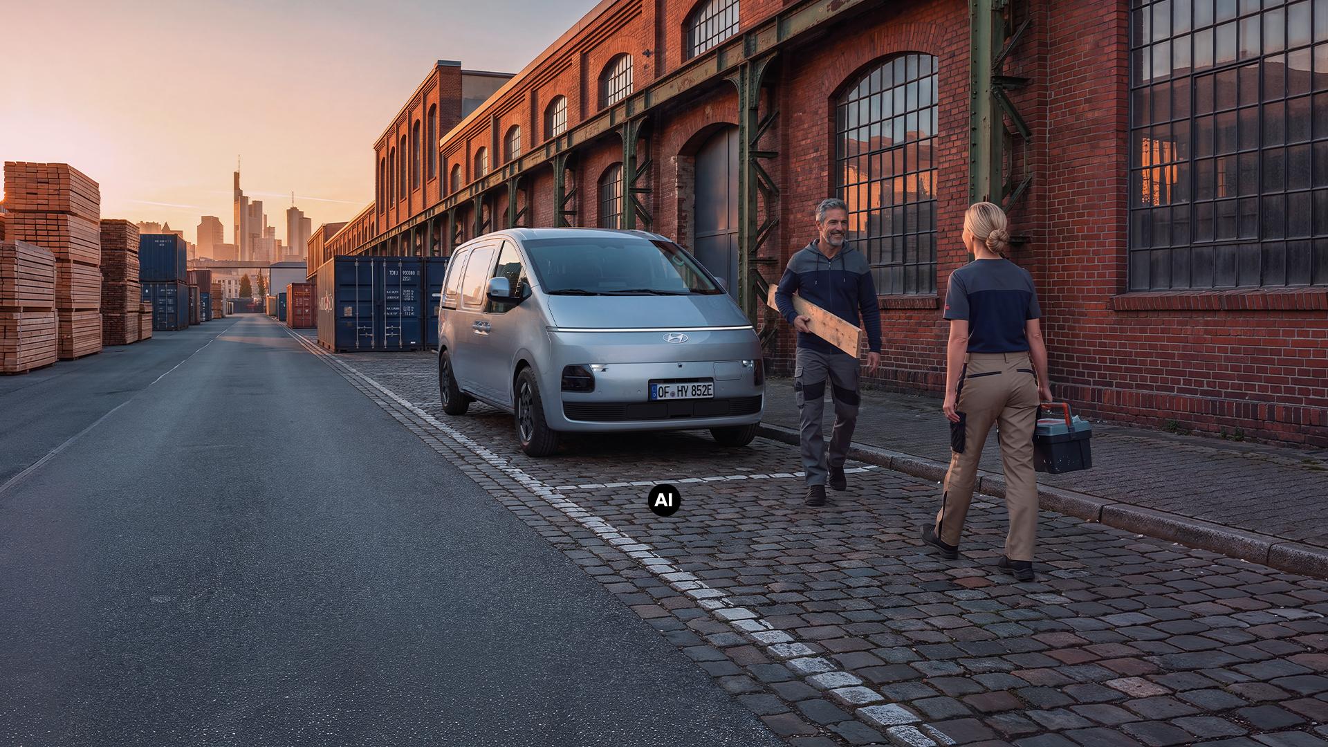 Ein Hyundai Staria Cargo Elektro vor einem Industrie-Lagerhaus.