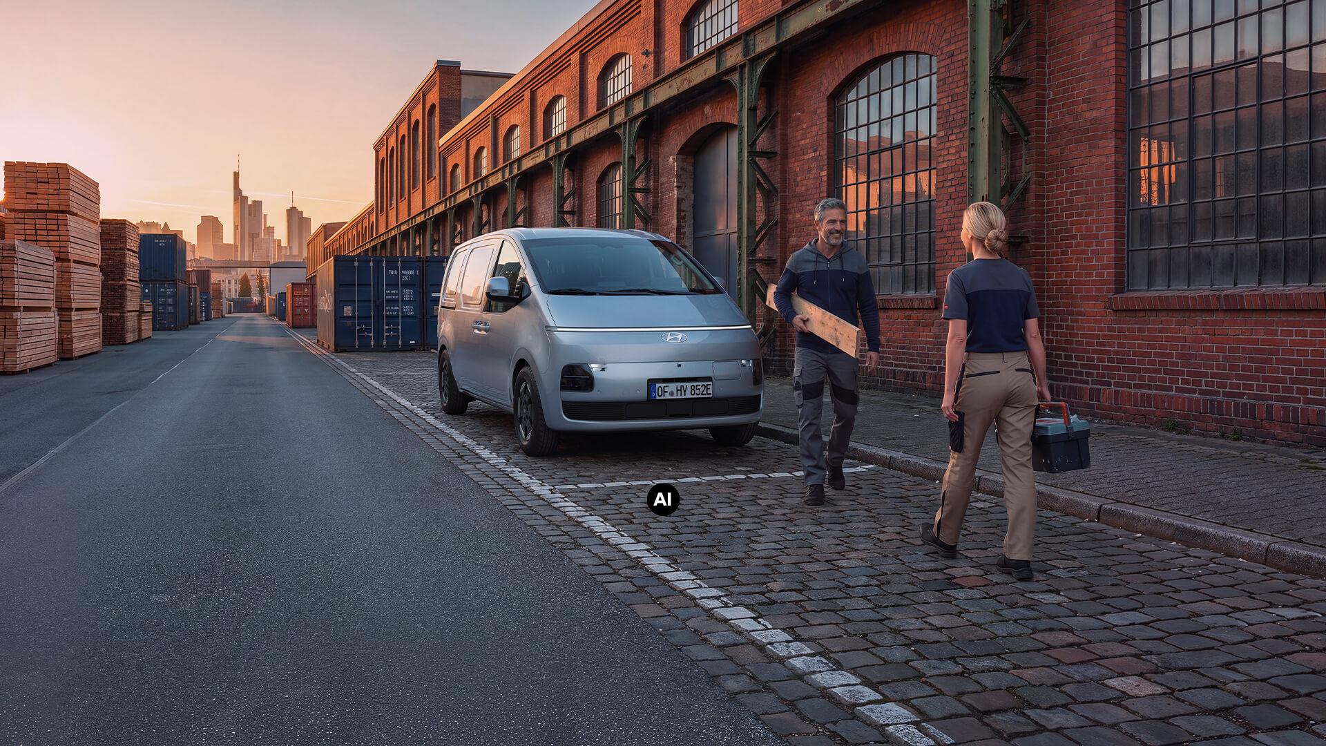Ein Hyundai Staria Cargo Elektro vor einem Industrie-Lagerhaus.