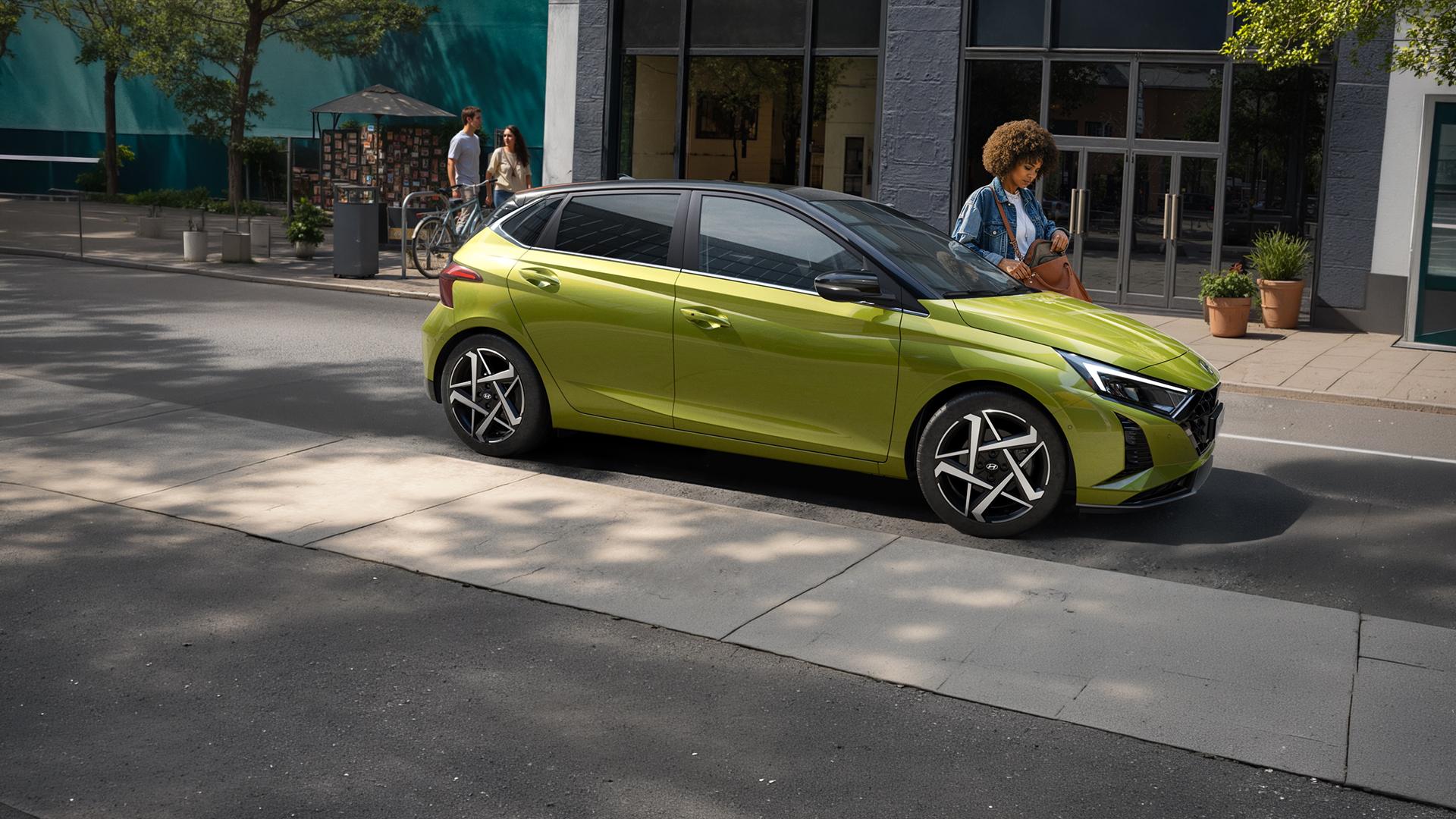 Une jeune femme sortant de sa Hyundai i20 dans une rue passante
