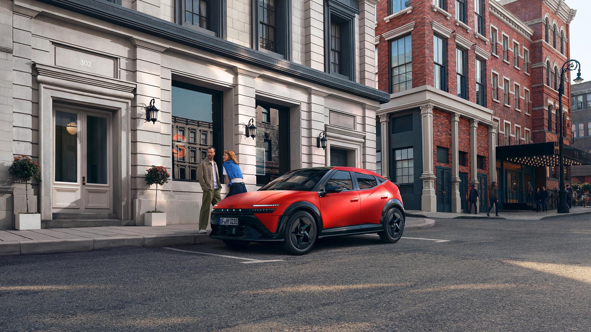 Ein roter Hyundai IONIQ 3, der auf einer Stadtstraße geparkt ist, dargestellt aus einer vorderen Dreiviertelansicht.