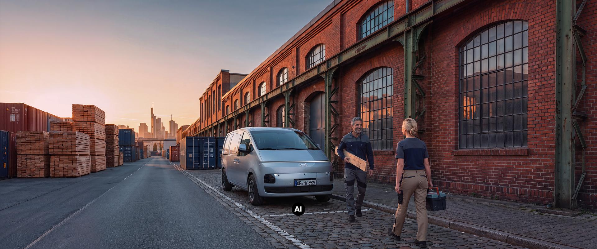 Ein Hyundai Staria Cargo Elektro vor einem Industrie-Lagerhaus.