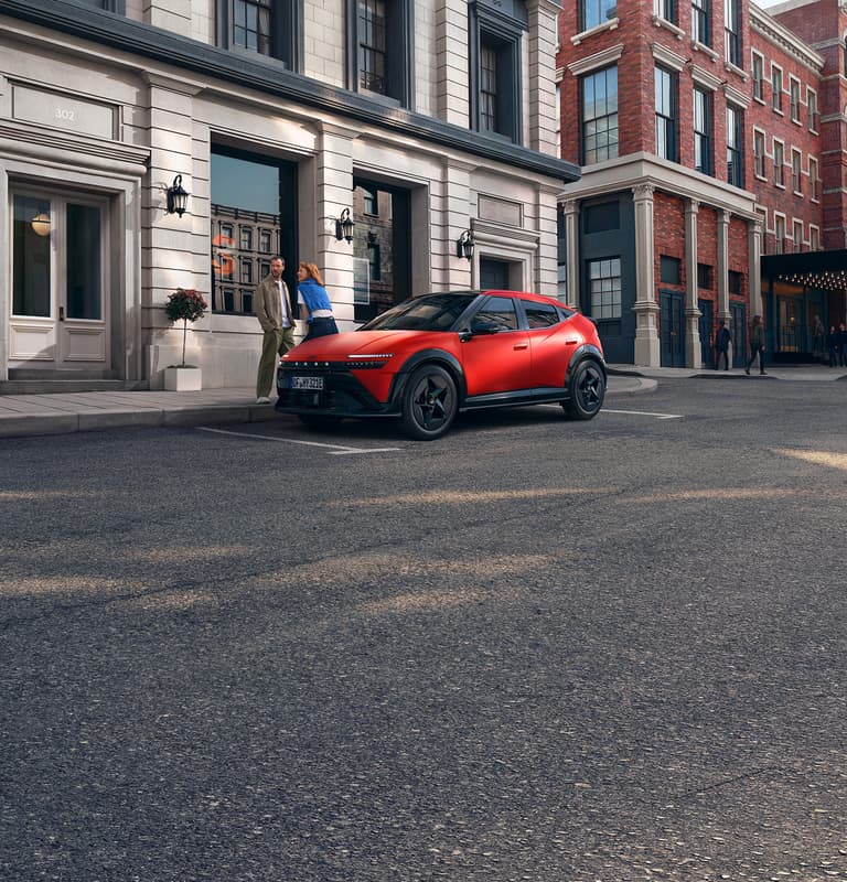 Ein roter Hyundai IONIQ 3, der auf einer Stadtstraße geparkt ist, dargestellt aus einer vorderen Dreiviertelansicht.