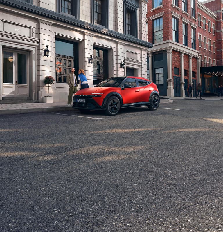 Ein roter Hyundai IONIQ 3, der auf einer Stadtstraße geparkt ist, dargestellt aus einer vorderen Dreiviertelansicht.