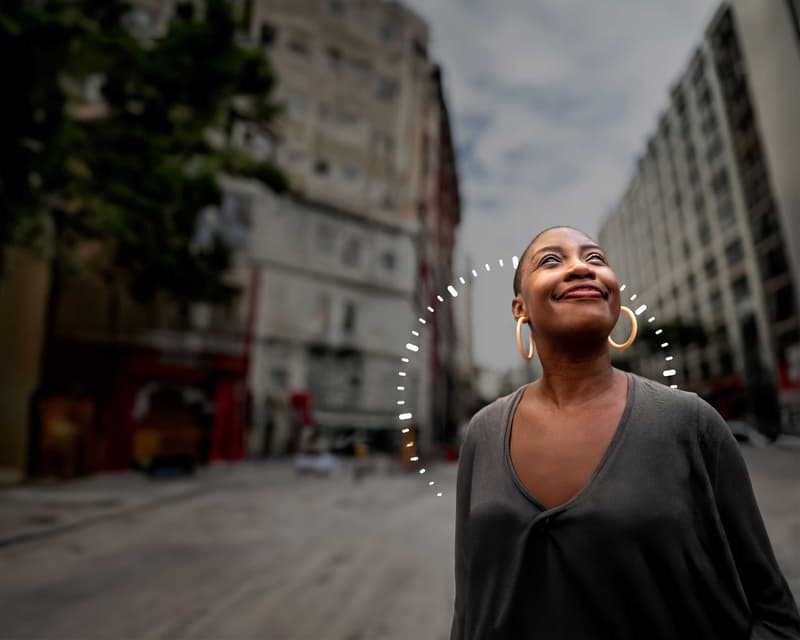 Une femme souriant en pleine rue