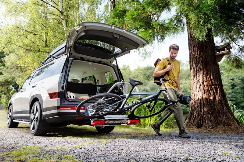Der Hyundai SANTA FE mit geöffneter Heckklappe und einem Fahrrad auf dem Fahrradträger der Anhängerkupplung.