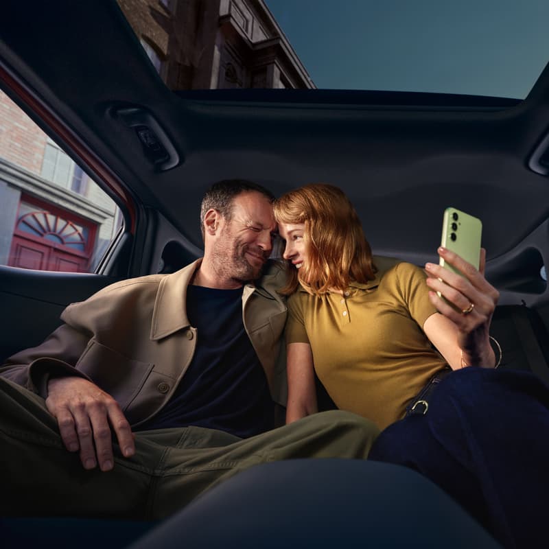 Två personer sitter i en Hyundai och tar en bild med en mobiltelefon.