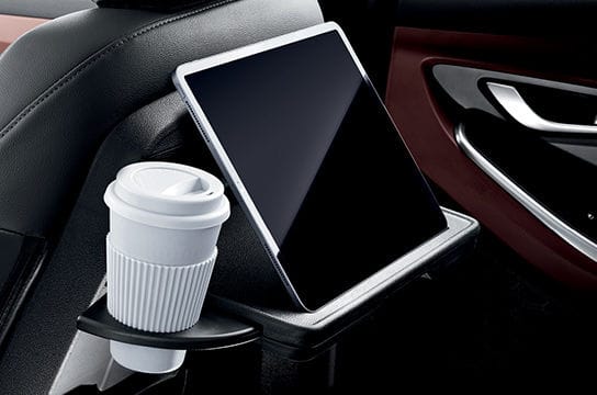 Front row seatback table with retractable cup-holder and IT device holder