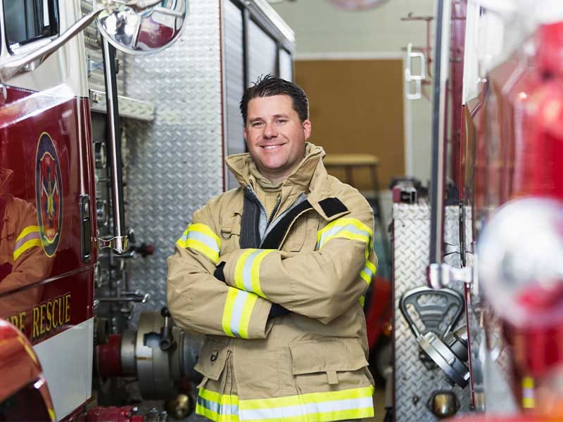 A firefighter standing beside emergency vehicles, highlighting Hyundai Fleet's support for everyday heroes and essential community services.