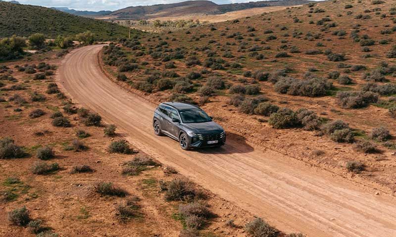 Hyundai Tucson SUV driving on a desert road