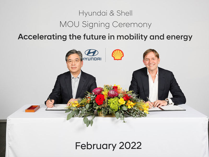 HMC president and Shell Downstream Director seated side-by-side after signing partnership