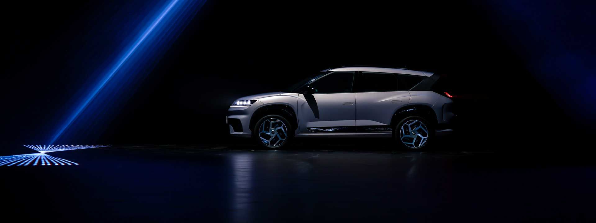 Hyundai ELEXIO electric SUV in a dramatic blue-lit setting, showcasing futuristic design, bold contours, and advanced EV styling.