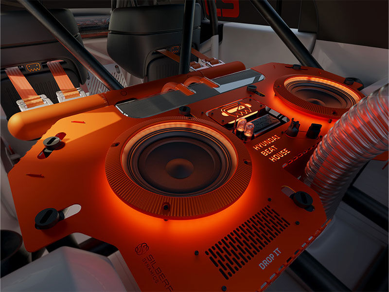 The Hyundai INSTEROID Concept Car interior features a bold “Hyundai Beat House” setup—blending performance with a club-ready DJ station, glowing orange audio gear, and race-inspired design for a truly immersive driving experience.