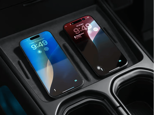 Close-up view of two smartphones charging simultaneously side-by-side on the dual wireless charging pad located in the center console of the Hyundai ELEXIO.