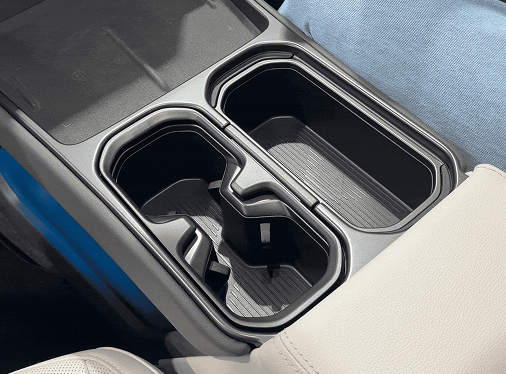 Top-down view of the flexible center console in the Hyundai ELEXIO, showing the adjustable and retractable dual cup holder compartments next to the armrest.
