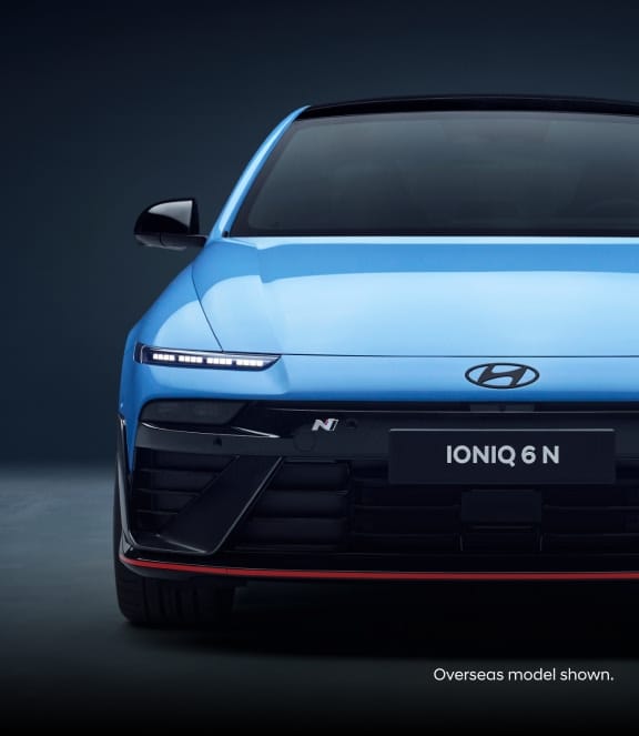 A close-up front view of a blue Hyundai Ioniq 6 N showcasing its grille and headlights