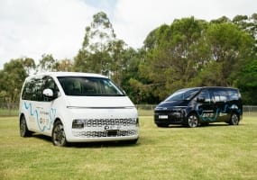 Hyundai STARIA parked on a lush green area , with the Hyundai help for Kids 