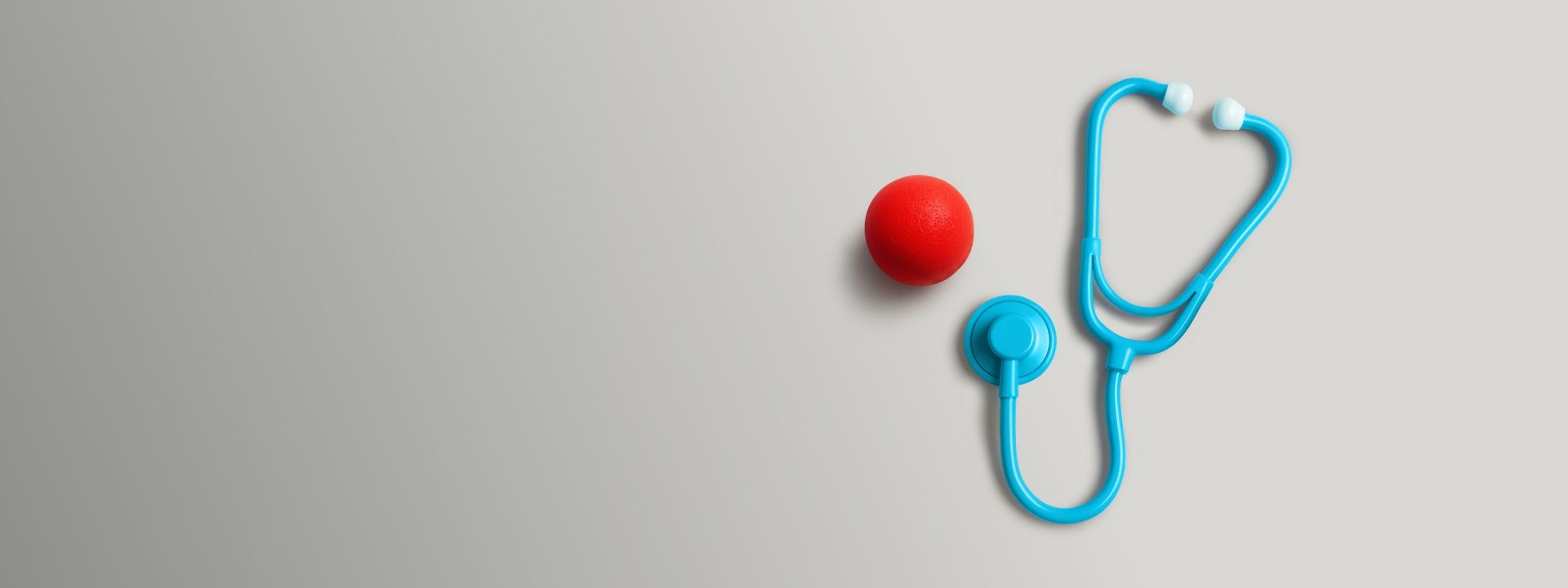 Heart-shaped stethoscope and red clown nose symbolizing healing through laughter—featured in Hyundai Help for Kids’ partnership with Clown Doctors, bringing joy and emotional care to children in hospitals.