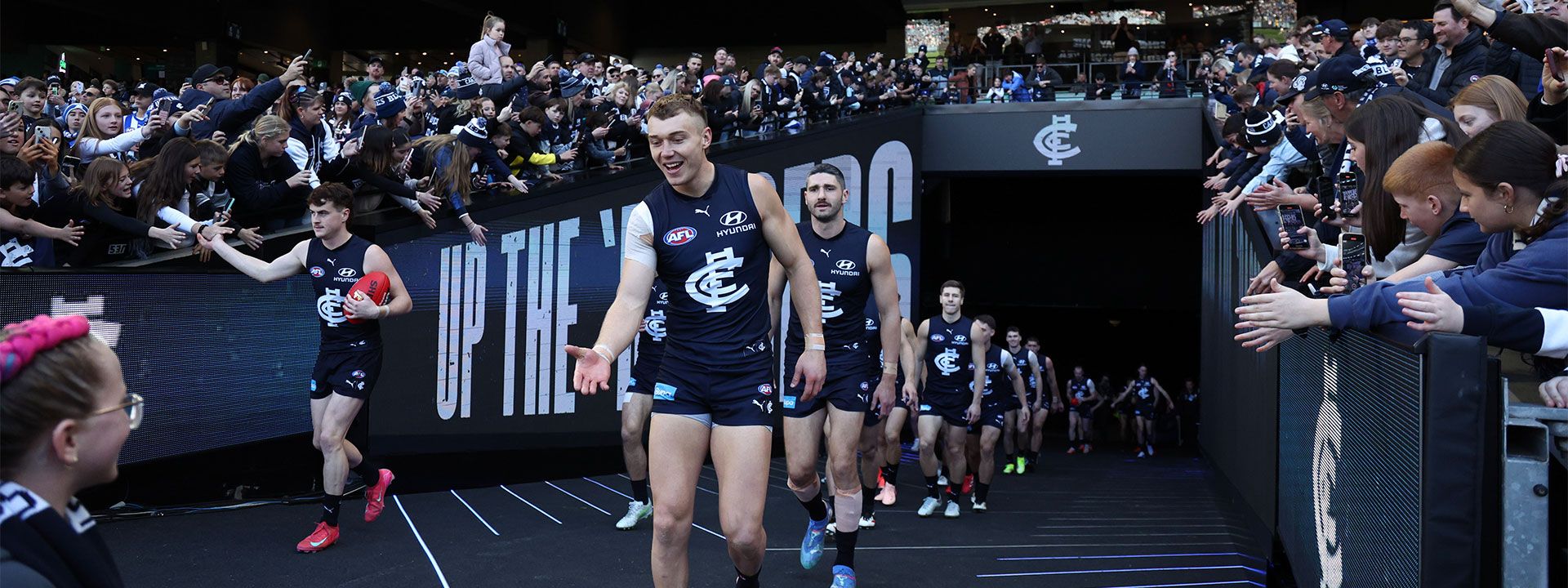 Carlton FC’s elite presence meets Hyundai’s prestige as players stride onto the field in navy blue, embodying performance, innovation, and premium partnership.