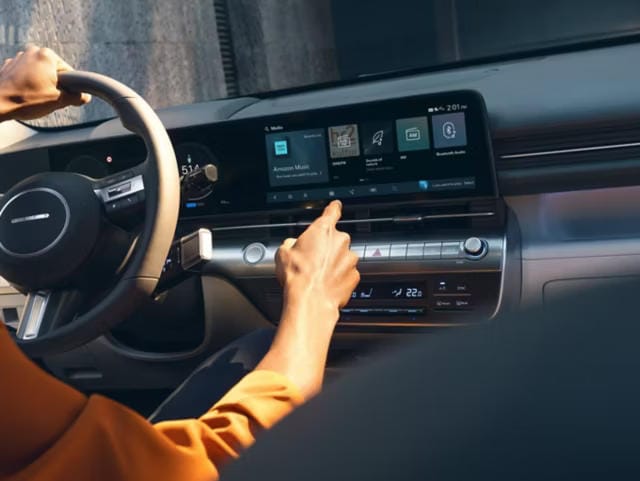 Una persona utilizando la pantalla táctil central en el interior del Hyundai KONA.
