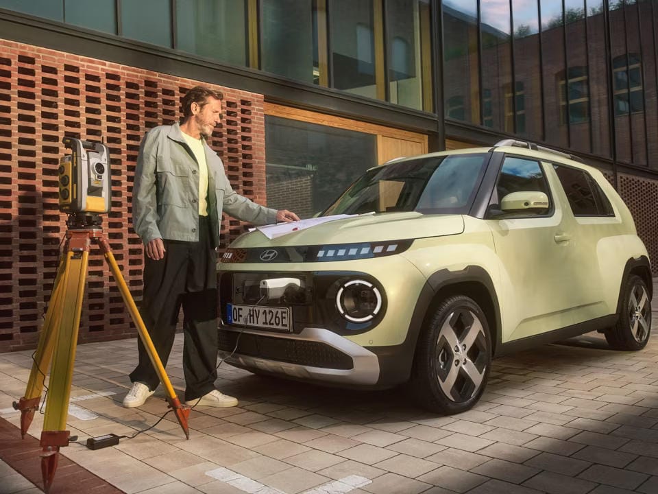 Hyundai INSTER con un convertidor enchufado al puerto de carga exterior para la capacidad de vehículo a carga. 