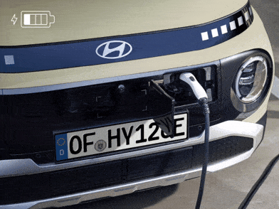 Hyundai INSTER con un convertidor enchufado al puerto de carga exterior para la capacidad de vehículo a carga. 