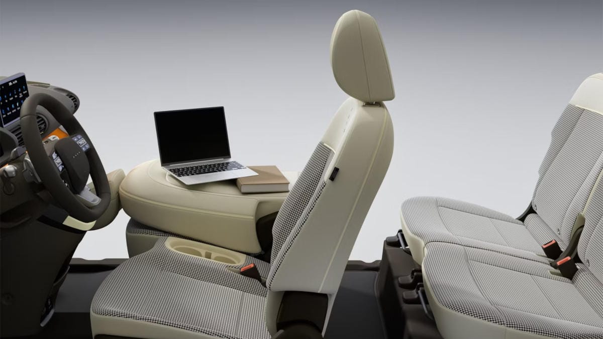 Vista lateral del asiento del pasajero plegado con un ordenador portátil en el interior del nuevo Hyundai INSTER.