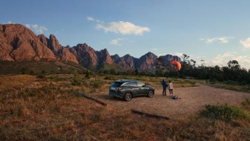 El Hyundai TUCSON aparcado con montañas al fondo.