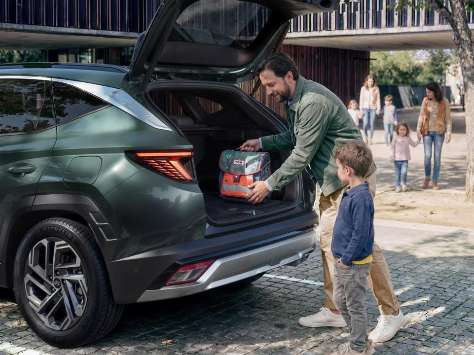 El Hyundai TUCSON aparcado en un camino de grava en el bosque. 