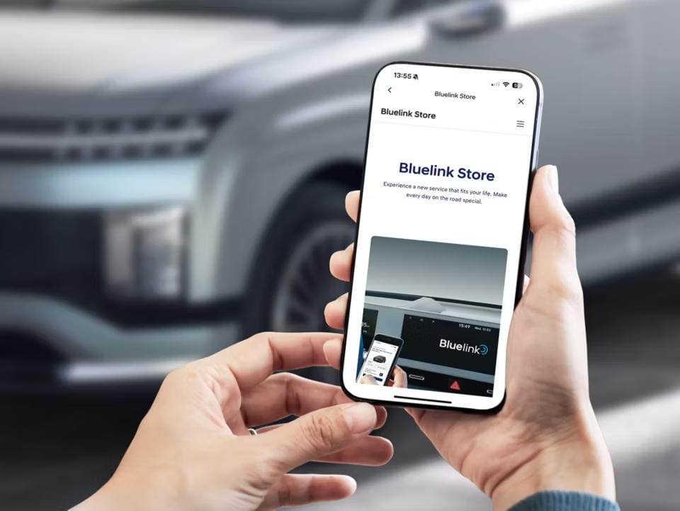 Perspectiva por encima del hombro, una persona está revisando la Tienda Bluelink. El fondo es IONIQ 9.