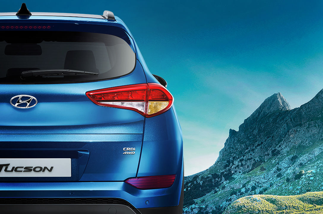 Rear view of blue Tucson with mountain background