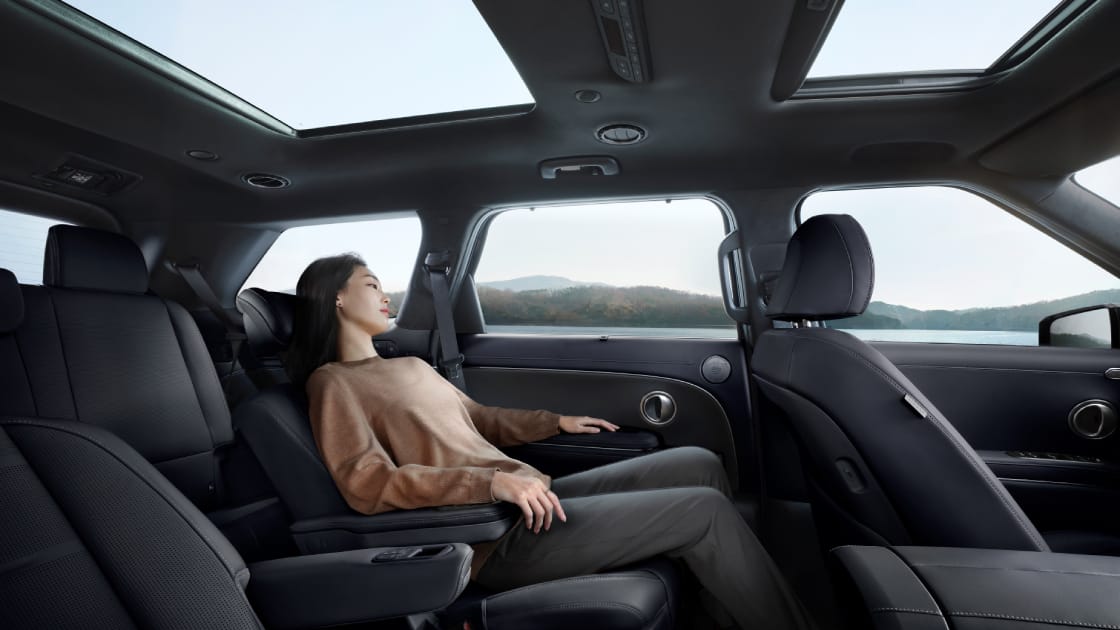 A woman relaxing in the second row seat inside the all-new PALISADE