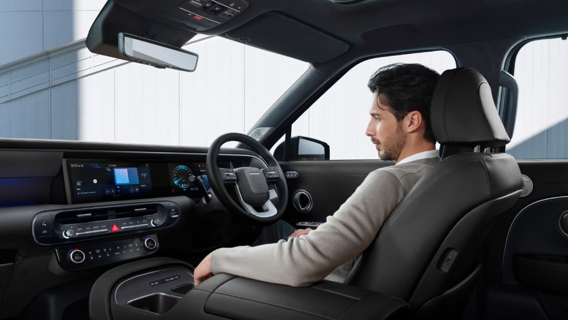 A man relaxing comfortably in the all-new PALISADE during STAY Mode