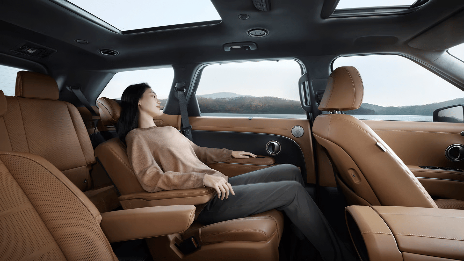 A woman relaxing in the second row seat inside the all-new PALISADE