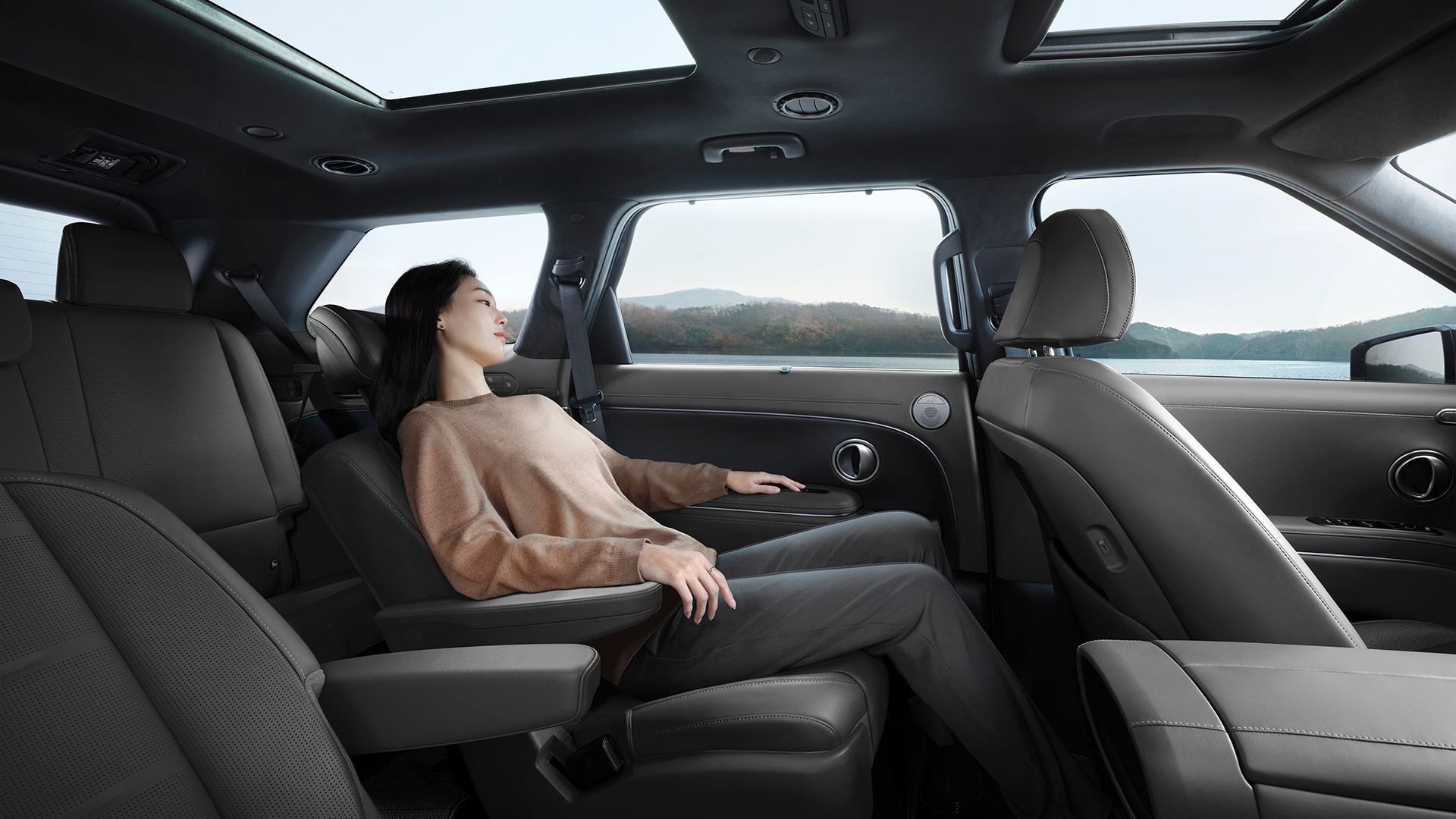 A woman relaxing in the second row seat inside the all-new PALISADE
