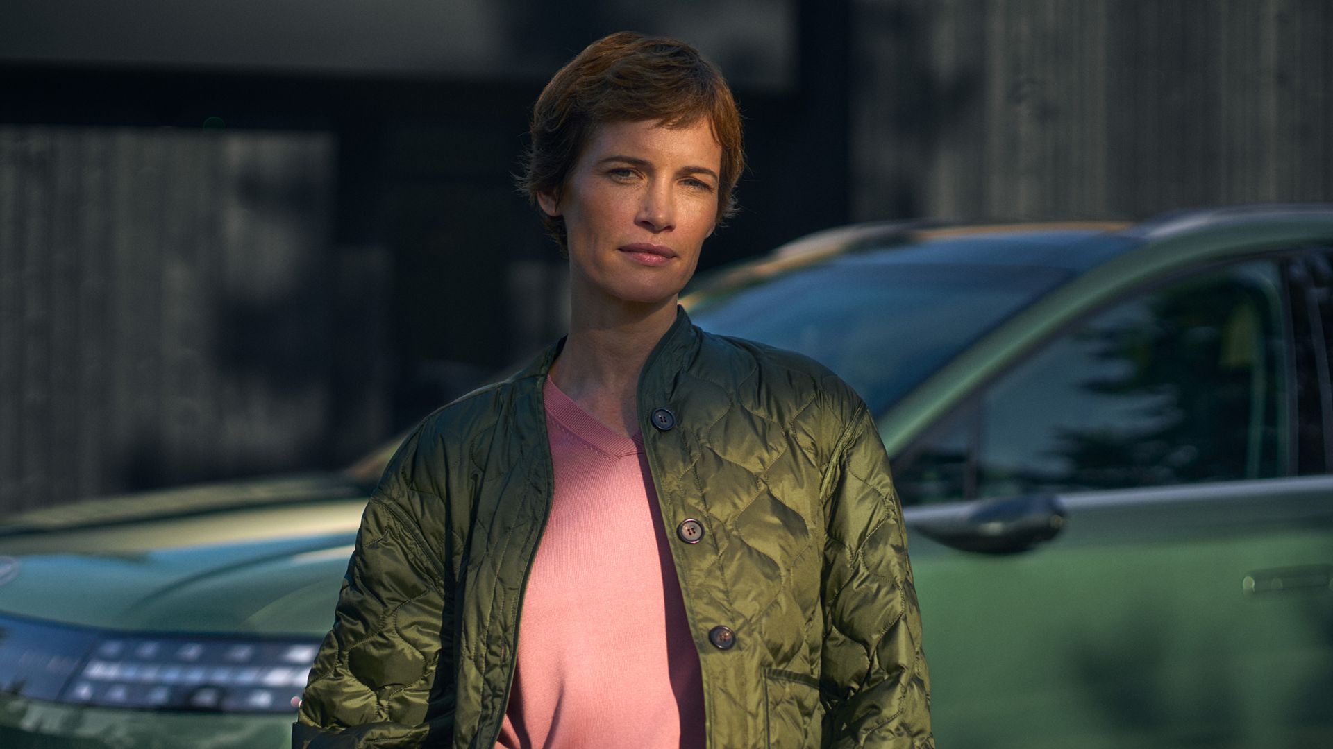 En dame står fpran en IONIQ 9. Foto.