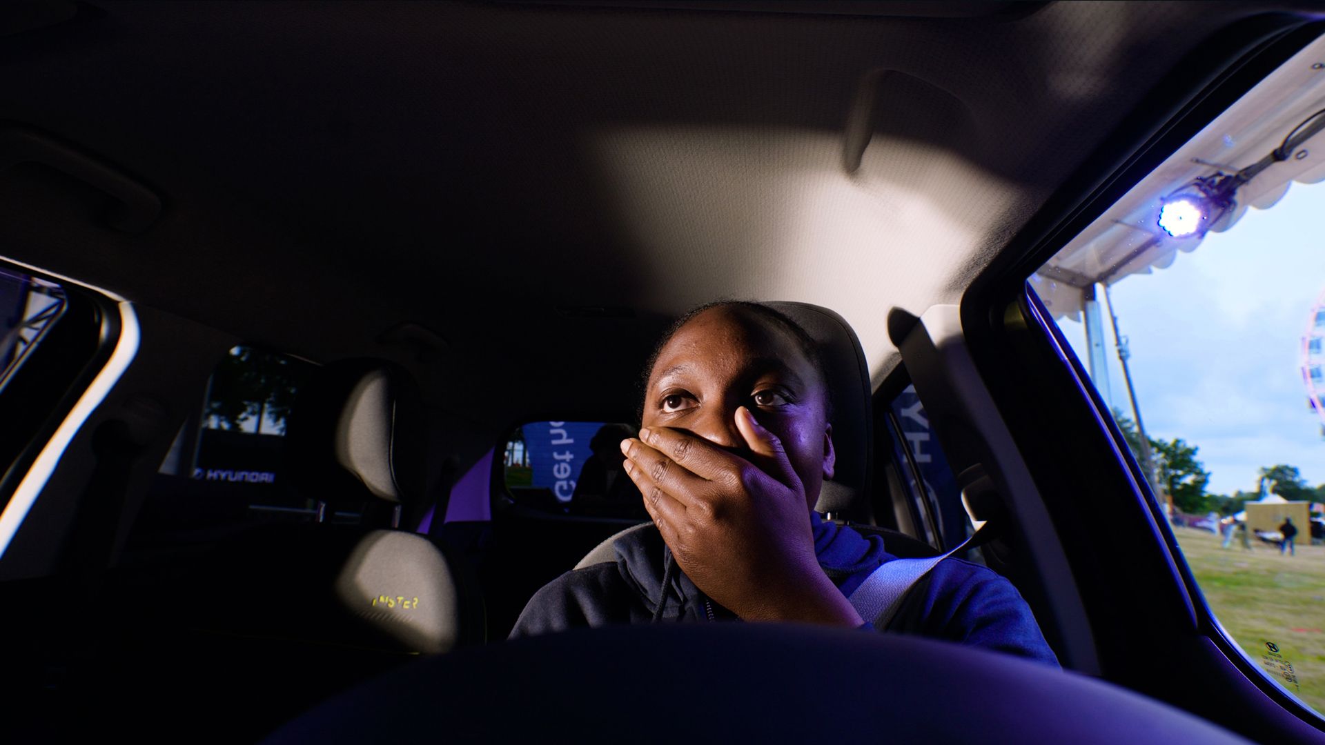 En ung dame prøver kjøresimlulatoren. Foto.