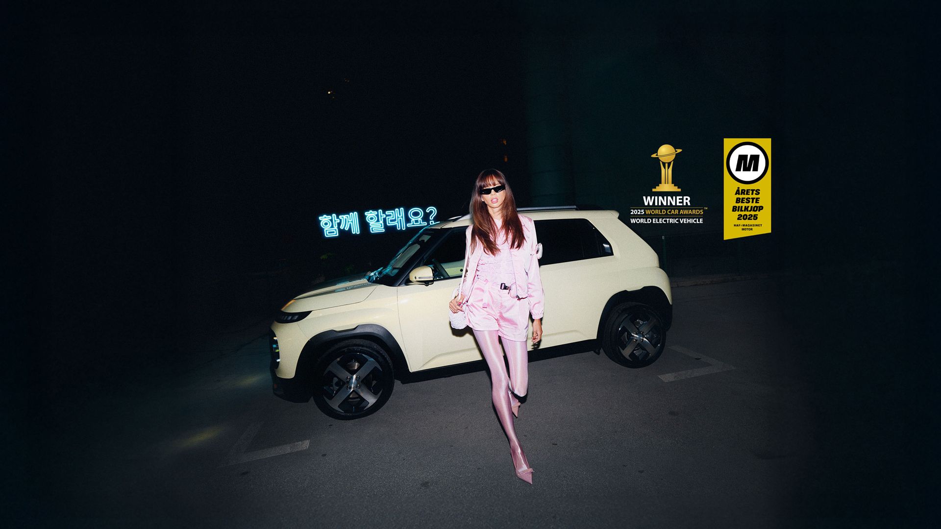 En stilig dame går foran elbilen INSTER. Foto.