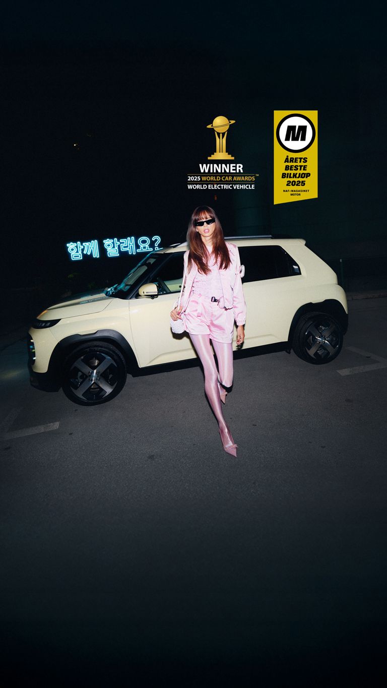 En stilig dame går foran elbilen INSTER. Foto.