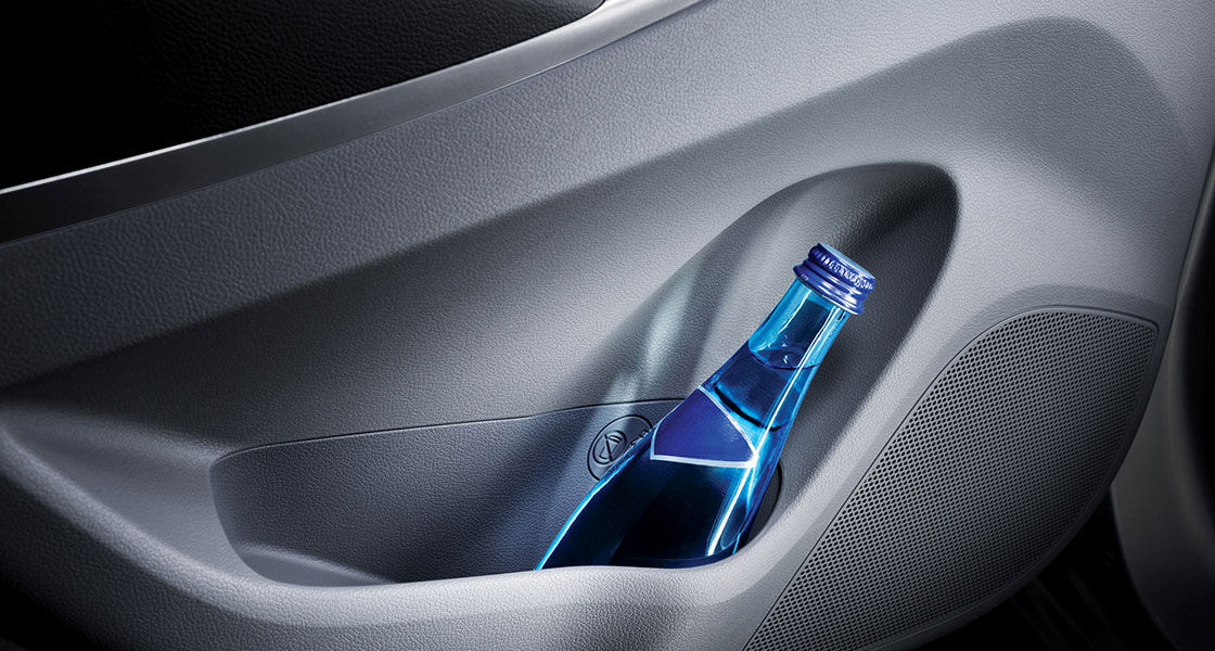 A blue bottle of drink stored in the door panel
