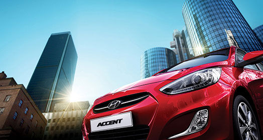 Low view of front red Accent with city towers as a background