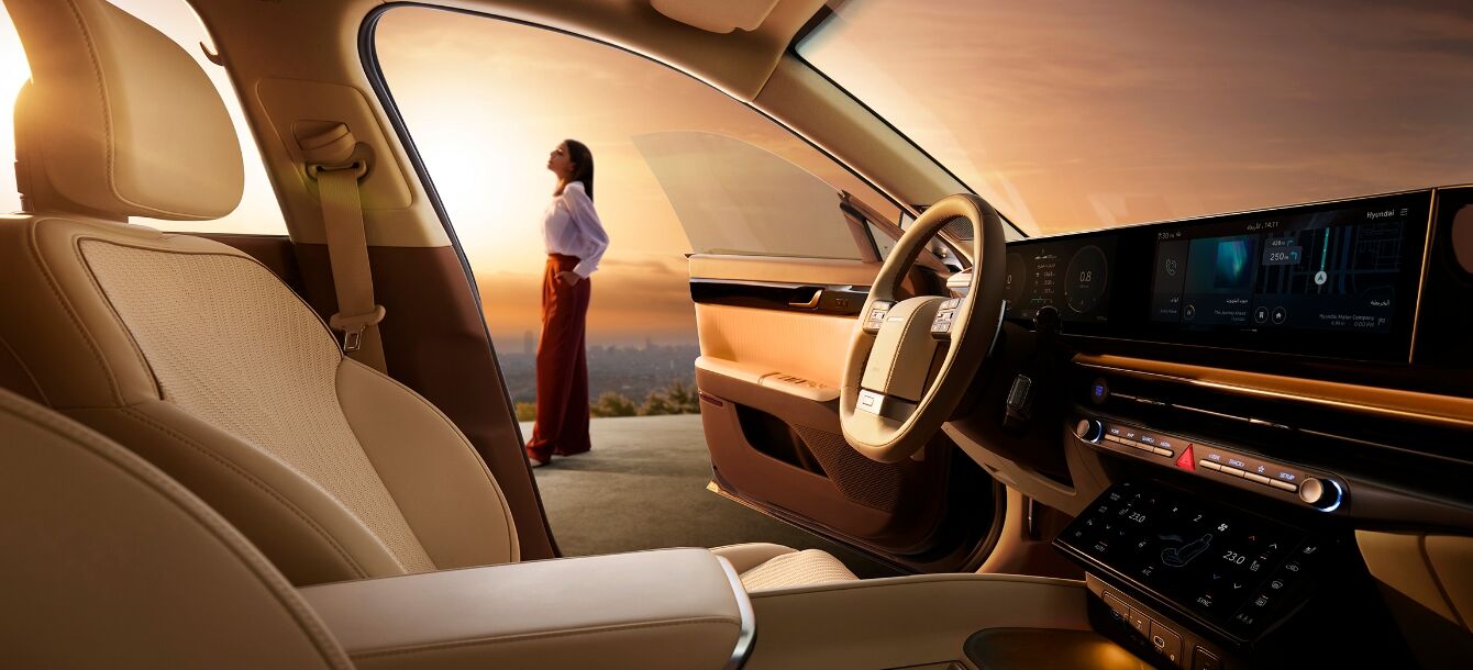 A woman is looking at sunset in front of the AZERA