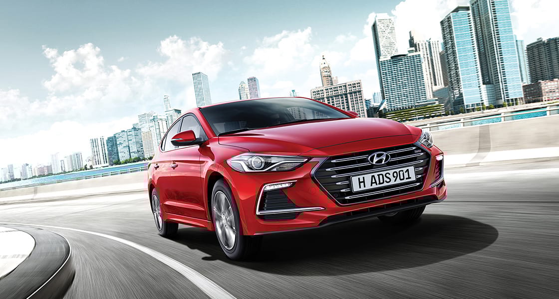 Right side front view of red Elantra Sport driving on the road