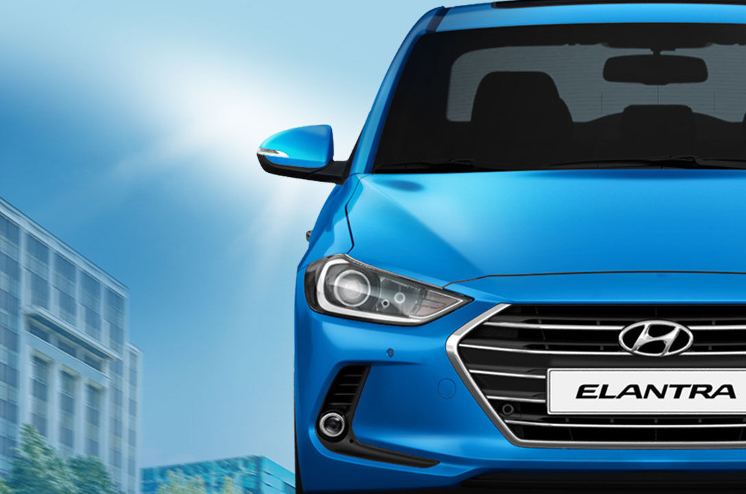 Front view of blue Elantra on a sunny day