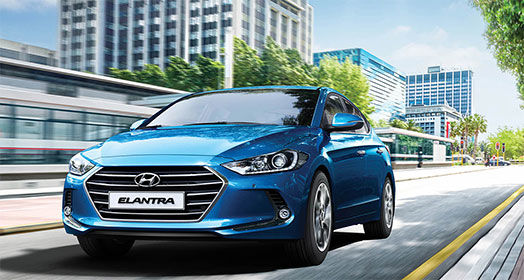 Front view of driving blue Elantra on the road in the city