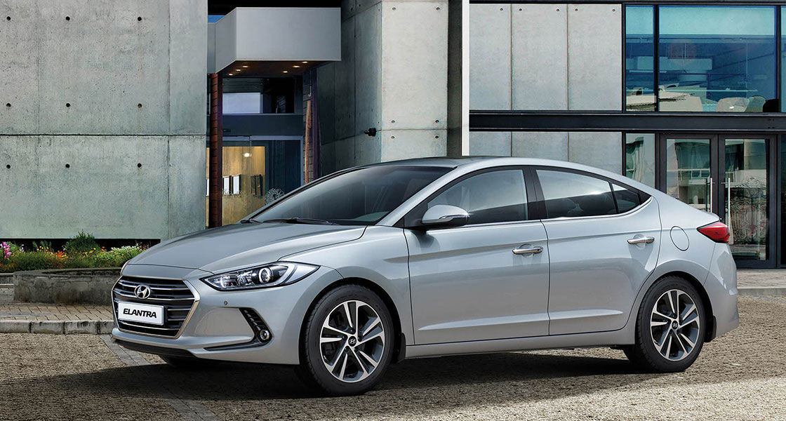 Left side view of silver Elantra parked in front of the building